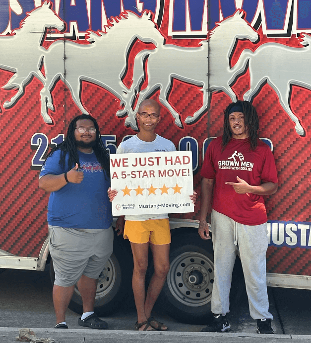 Mustang Moving customer DeShawn P. with two crew members in front of a Mustang Moving truck.