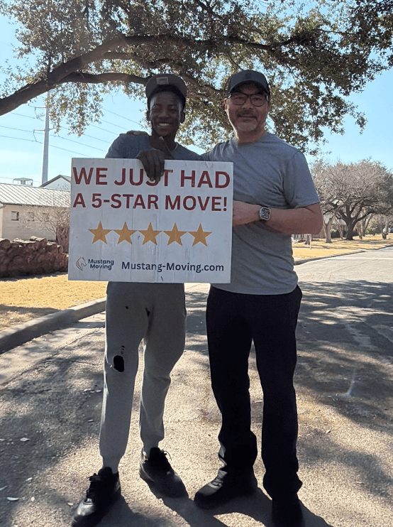 Mustang Moving customer Andre T. with a crew member on a tree-lined street.