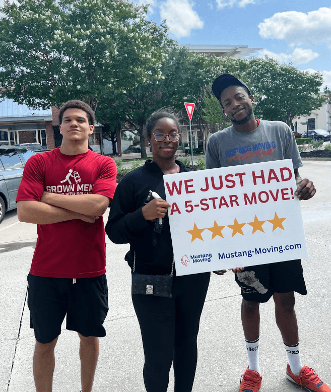Mustang Moving customer Olivia C. with two crew members holding a 5-star move sign on a quiet Dallas street.